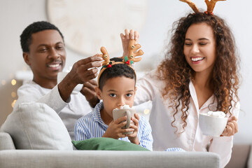 Poster - Happy African-American family drinking tasty hot chocolate at home on Christmas eve