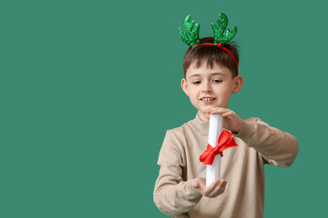 Sticker - Funny little boy with reindeer horns and scroll on color background