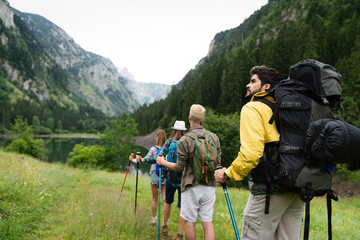 Group of young friends hiking in countryside. Multiracial happy people travelling