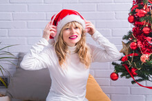 Relaxed Woman With Headphones And Santa Claus Hat At Christmas