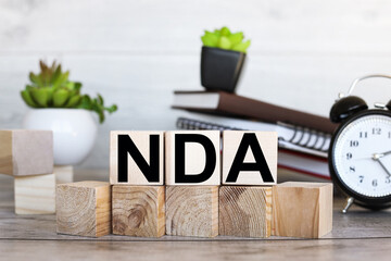 NDA. text on wood blocks near a notebook on a work table