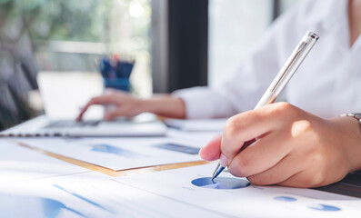 Wall Mural - businesswoman working at office with document on her desk, doing planning analyzing the financial report, business plan investment, finance analysis concept.	