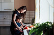 mother and son prepare a salad of vegetables in the kitchen