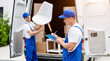 © romaset - Two removal company workers unloading boxes from minibus into new home