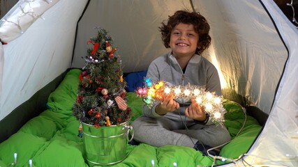 Europe, Italy , MIlan , Boy child 7 years old  Christmas lifestyle family at home - celebrate Christmas in the tent camping home during lockdown due Covid-19 Coronavirus - desire to travel 