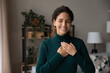 © fizkes - Smiling young Hispanic woman hold hands at heart chest feel grateful and thankful. Happy millennial Latino female believer show love and care support pray or mediate. Faith, superstition concept.