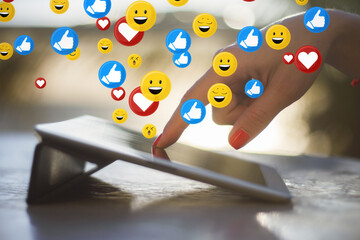 Poster - Close up of female hand using tablet on desktop with social media icons. Blurry background. Communication, internet and network concept.