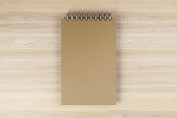 Wall Mural - Top view and close up of brown spring note pad on wooden desktop background. Mock up place for your advertisement. Education, work, supplies and stationery concept. 3D Rendering.