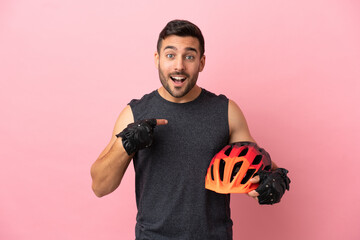 Poster - Young cyclist man isolated on pink background with surprise facial expression