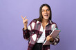 © luismolinero - Young student woman isolated on purple background intending to realizes the solution while lifting a finger up