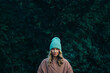 © Zamrznuti tonovi - Beautiful young stylish woman wearing coat and a cap in the park