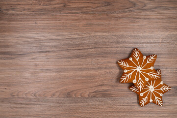 Wall Mural - Two gingerbread stars with white glaze and silver beads on a wooden table. Copy space.