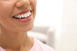 © New Africa - Young woman with healthy teeth on blurred background, closeup. Space for text
