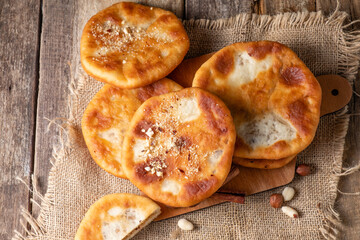 Wall Mural - Hotteok Korean fried dough dessert with nuts on a wooden table. View from above. Flat lay.