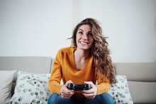 Young Woman Playing Video Game At Home