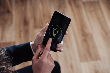 Businesswoman holding smart phone with flashlight icon