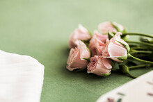Studio Shot Of Small Bouquet Of Pink Roses Lying Against Green Background