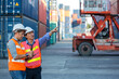 © kanpisut - Foreman man working checking at Container cargo harbor to loading containers. Professional foreman work at Container cargo site check up  goods in container. Workers are opening containers for check.