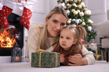 Sticker - Happy mother and her daughter with Christmas gift in festively decorated room