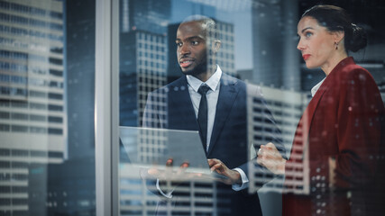 Leinwandbilder - Portrait of Successful Corporate CEO and Investment Manager Talking, Using Laptop Computer while Standing in City Office. Stock Market Businesspeople Negotiate e-Commerce Software Purchase
