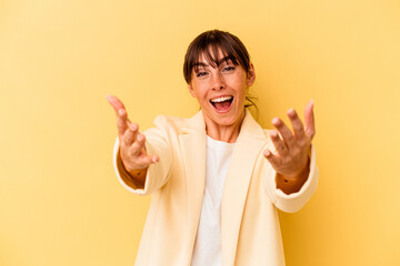 Young Argentinian woman isolated on yellow background celebrating a victory or success, he is surprised and shocked.