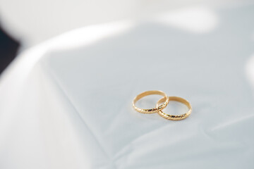 Gold wedding band or rings as bond of love on table covered with linen cloth