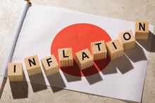 Japanese Flag And Wooden Cubes With Text, Concept On The Theme Of Inflation In Japan