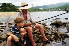 Grandfather Fisher In Straw Hat And Little Male Grandkid Enjoying Leisure Activity Use Fishing Rod