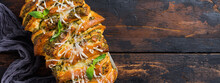 Pull-apart Bread With Italian Pasta Pesto, Basil And Parmesan Cheese In Baking Form Over Old Dark Concrete Background. Top View. Rustic Stile.