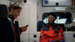 © stockbusters - Smiling paramedic doctor talking with afro medical worker in emergency car