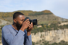 Man with black skin taking photos with dslr camera