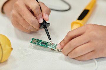 close up of child making science experiments with electricity in classroom