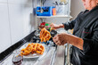 © Sangiao_Photography - Peru Latin senior chef cooking Picarones in professional small business kitchen