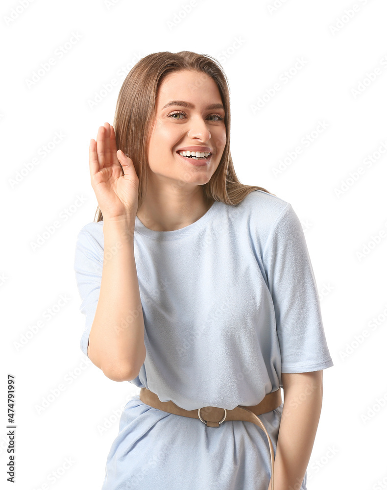Young woman trying to hear something on white background