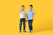 © Pixel-Shot - Two boys in casual clothes on yellow background