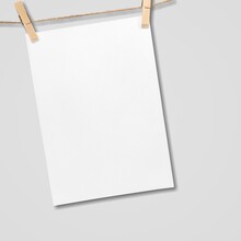 Paper Hanging On Rope With Wooden Clothespins On Background