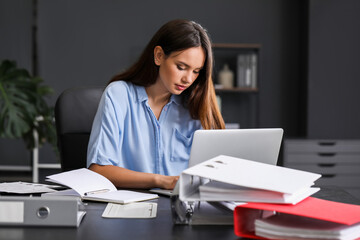 Young woman working with documents in office