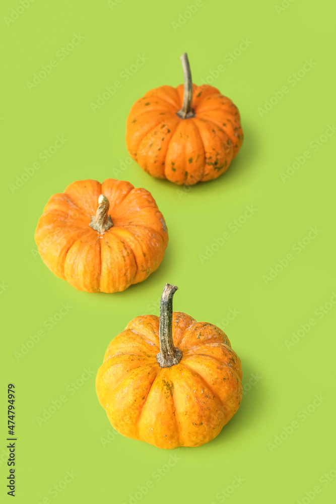 Ripe beautiful pumpkins on green background