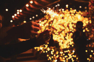 Two hands with sparklers on a Christmas or New Year's eve background