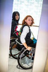 Wall Mural - Two girls in wheelchairs in an elevator accessible to people with special need go up to the next floor.