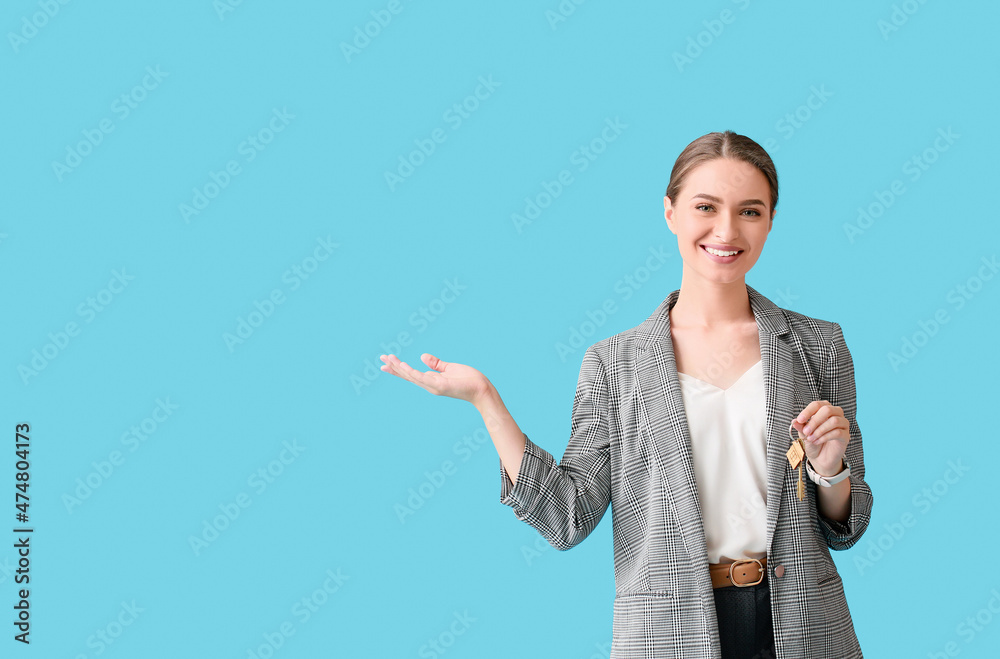 Real estate agent with key from house on blue background