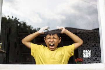 Boy screaming and crying alone at home. Childhood traumatic experience, psychology, psychological, asperger syndrome, asperger's disorder, autistic, autism.