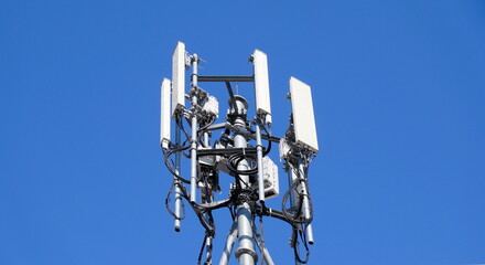 Wall Mural - Telecommunication tower of 4G and 5G cellular. Macro Base Station. 5G radio network telecommunication equipment with radio modules and smart antennas mounted on a metal against blue sky background.