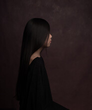 Classic Studio Portrait Of Child With Long Black Hair Seen From Side In Renaissance Style