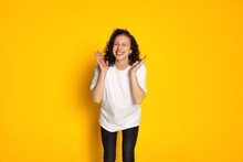 Portrait Of Smiling Young Beautiful Girl In White T-shirt And Jeans Laughing Isolated On Yellow Background