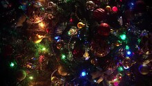 Decorated Christmas Tree Background Close Up. Beautiful And Rich Decorated Christmas Fir Tree On The Street Of European City. Close Up A Christmas Tree Lights Glittering At Night. New Year Tree With D