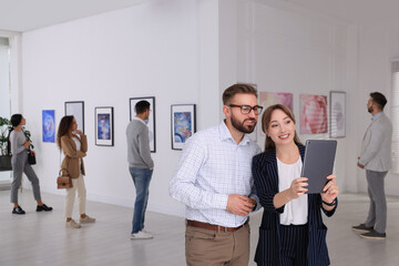 Wall Mural - Happy couple with tablet at exhibition in art gallery