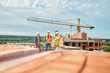 © zinkevych - Men standing at top of unfinished house discussing