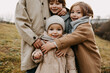 © Bostan Natalia - Closeup of brothers hugging little sister, smiling, outdoors on autumn day.