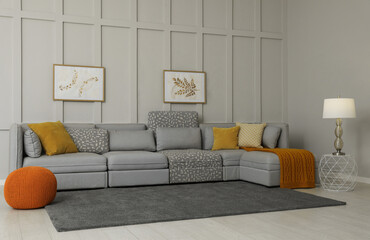 Sticker - Comfortable large sofa with cushions and knitted blanket in living room